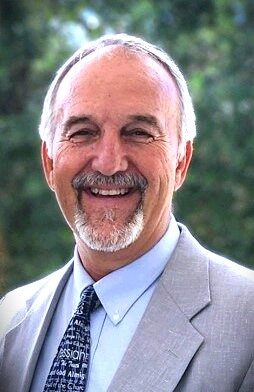 Smiling man in a suit and tie.