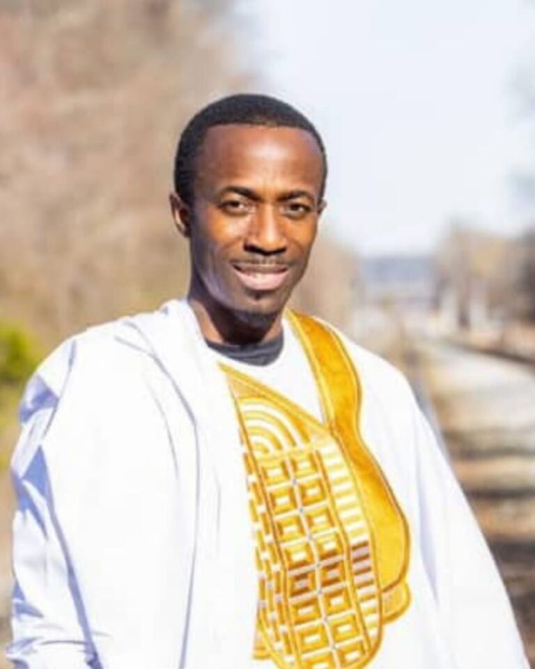 Kojjo Opoku-Reeves wearing a white and gold African-inspired outfit.