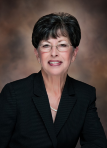 Professional headshot of Barbara Freeman wearing a suit and glasses.