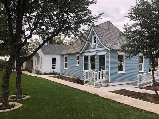 Blue and white historic homes with green lawn.