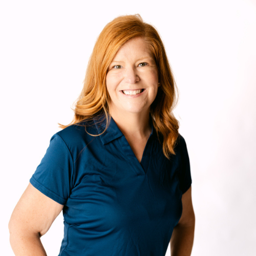 Kristi Sheehan, smiling in a blue polo shirt