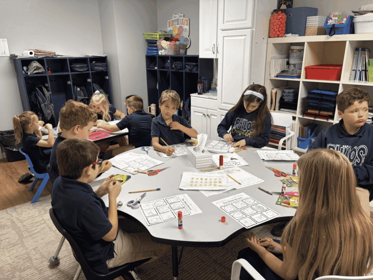 Students at Philos Classical Christian School work on assignments at tables.