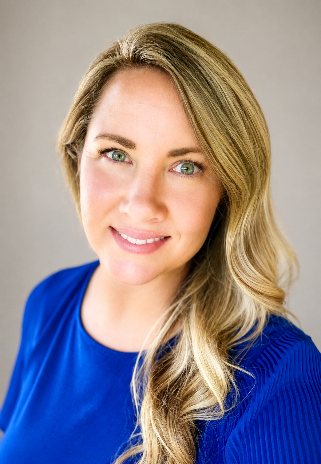 Professional headshot of Karen Roush, a blonde woman with green eyes smiling.
