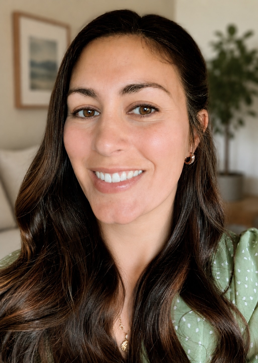 Natalie Janoe, a woman with long brown hair, smiles at the camera.
