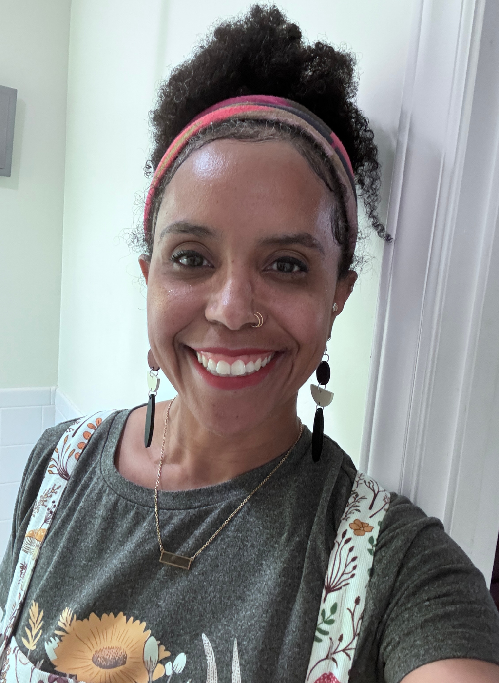Amanda Desjardin smiles in a close-up portrait, wearing a floral apron.